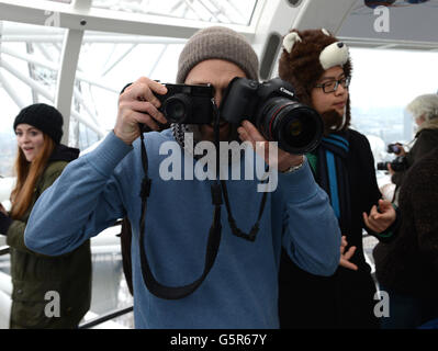 1000 Menschen trotzten den widrigen Wetterbedingungen am EDF Energy London Eye heute Morgen und stellten sich im Schnee für die Wiedereröffnung des 'Lift London' und eine freie Rotation an. Stockfoto