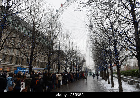 1000 Menschen trotzten den widrigen Wetterbedingungen am EDF Energy London Eye heute Morgen und stellten sich im Schnee für die Wiedereröffnung des 'Lift London' und eine freie Rotation an. Stockfoto