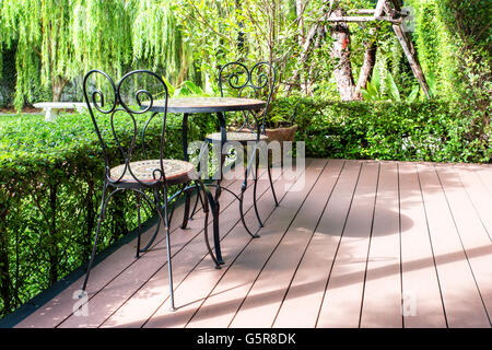 Schwarzen Stuhl im Garten zum entspannen. Grünen Garten und Innenhof-Terrasse im Haus. Klassische Garten mit schwarzen Stuhl auf Terrasse ich Stockfoto