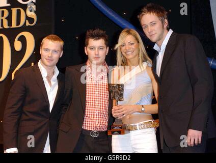 CD-UK-Moderatoren Brian Dowling (2. Links), Tess Daly und James Redmond (rechts) erhalten ihr Musik- und Kunstprogramm des Jahres von Sänger Ronan Keating. *.... während der TRIC (Television & Radio Industries Club) Awards 2002 im Le Meridien Grosvenor House Hotel in London. Stockfoto