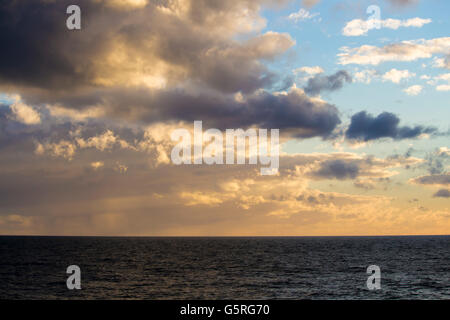 Eine trübe Sonnenuntergang in einem dunklen australischen Himmel über das farblose Meer im Ocean Beach, Bunbury, Western Australia im späten Winter. Stockfoto