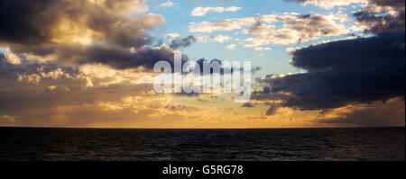 Eine trübe Sonnenuntergang in einem dunklen australischen Himmel über das farblose Meer im Ocean Beach, Bunbury, Western Australia im späten Winter. Stockfoto