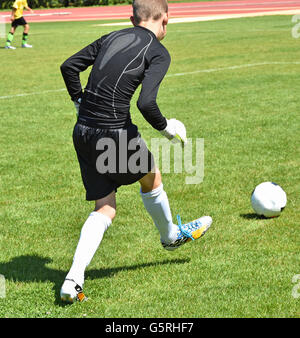 Junge Torhüter startet den ball Stockfoto