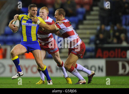 Simon Grix von Warrington Wolves wird von den Wigan Warriors Lee Mossop und Liam Farrell (links) während des Super League-Spiels im DW Stadium, Wigan, angegangen. Stockfoto