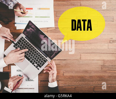 BUSINESS-TEAMS ARBEITEN IM BÜRO MIT DATEN REDE BLASE AUF SCHREIBTISCH Stockfoto