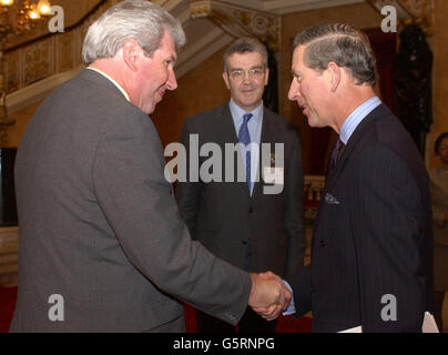 Der Prinz von Wales schüttelt die Hände mit dem Abgeordneten Elliot Morley und John Dew (Mitte), dem Leiter des Lateinamerika- und Karibikministeriums im Auswärtigen Amt, bevor Prinz Charles eine Konferenz über karibischen ökologischen Landbau im Zentrum von London ansprach. * der Prinz forderte die Supermärkte auf, seinem Beispiel zu folgen, als er seine eigene Schokoladenmarke aus biologischem Kakao aus Guyana herausbrachte, wo sein Engagement dazu beiträgt, eine verarmte Gemeinschaft wiederzubeleben. Charles sagte, dass seine von seinem Lebensmittelunternehmen Herzogtum Originals produzierten Dosen aus organischer dunkler Schokolade Indianer in den Guyanern erlaubten Stockfoto