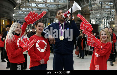 Der olympische Goldmedaillengewinnerin Anthony Joshua (2. Rechts) und die olympische Badmintonspielerin Susan Egelstaff (2. Links) werden mit den Glasgow 2014-Promotern Lynsey Laurie (links) und Sarah Bates (rechts) während einer Fotozelle zur Förderung der Suche nach Freiwilligen der Commonwealth Games in Glasgow 2014 im Glasgow Central Station, Glasgow, abgebildet. Stockfoto