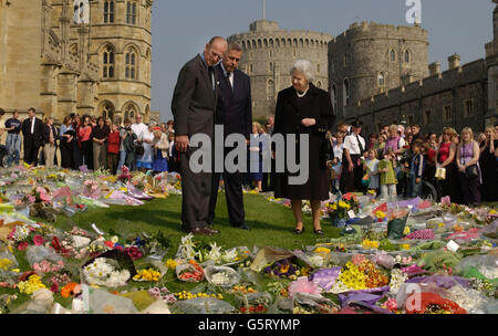 Die britische Königin Elizabeth II. Und der Herzog von Edinburgh, begleitet vom Superintendenten von Windsor Castle, Munro Davidson (Mitte), sehen sich die floralen Tribute an, die auf dem Schlossgelände von Brunnenflüstern hinterlassen wurden, um den Tod von Königin Elizabeth, der Königin Mutter, zu ehren. * Sie war 101 Jahre alt. Stockfoto