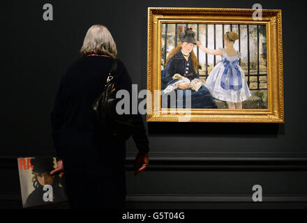 Ein Besucher blickt auf Edouard Manets „The Railway“ während einer Presseinterview zu „Manet:Portraying Life“, der ersten großen Ausstellung in Großbritannien, die Edouard Manets Porträts in der Royal Academy of Arts, London, zeigt. Stockfoto