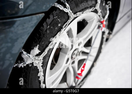 THULE CG-9 Schneeketten montiert und selbstgespannt am Hinterrad eines BMW. Snow-Chains helfen beim Fahren durch Schnee, besonders bei Fahrzeugen mit Hinterradantrieb, die viel anfälliger sind, aufgrund von Verlust an Traktion festzustecken. Stockfoto