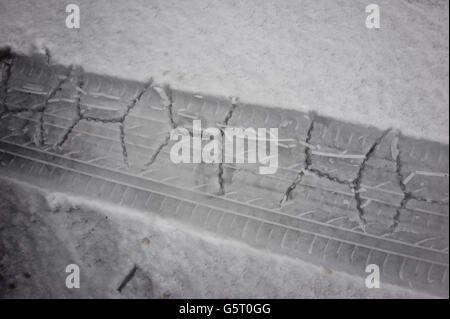 Das Profil zeigt Reifen- und Snow-Chain-Spuren, die von THULE CG-9 Snow-Chains im Schnee zurückgelassen wurden. Snow-Chains helfen beim Durchfahren von Schnee, insbesondere bei Fahrzeugen mit Hinterradantrieb, die aufgrund von Traktionsverlusten viel anfälliger sind. Stockfoto