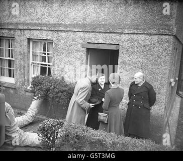 Die Königin wird von Norah Benton, einer 47-jährigen Frau eines Hafenarbeiters, in ihrem Haus in Feenan Highway, Tilbury, Essex, begrüßt. Das Haus des Paares, das erste, das die Königin bei Tilbury während ihrer Tour durch überflutete Gebiete von Essex und Kent besuchte, ist eines von Hunderten, die von Überschwemmungen im Bezirk verwüstet wurden. Stockfoto