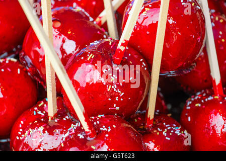Sweet glasiert rote Toffee Liebesäpfel auf Sticks für den Verkauf auf dem Wochenmarkt oder Jahrmarkt. Stockfoto