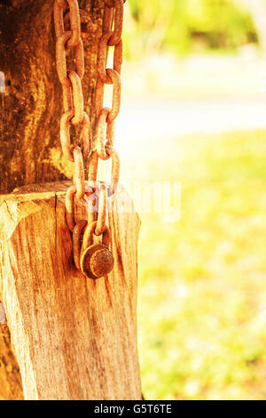 Die Ketten hängen auf das alte Holz im Garten. Stockfoto