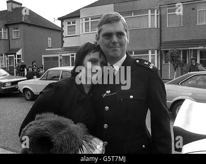 Nachbarn und Kinder schauen aus ihren Häusern in der Warley Road, Dagenham, heraus, während der Polizeibeamte Trevor Lock nach seiner sechstägigen Tortur bei der Belagerung der iranischen Botschaft mit seiner Frau Doreen nach Hause zurückkehrt. Stockfoto