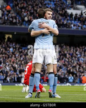 Edin Dzeko (rechts) von Manchester City feiert das erste Tor seiner Mannschaft mit Teamkollege James Milner Stockfoto