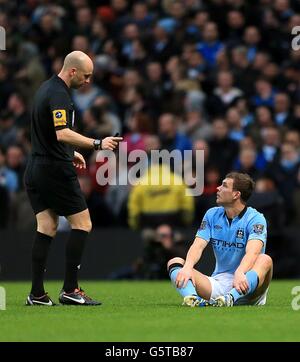 Edin Dzeko von Manchester City (rechts) spricht mit dem Schiedsrichter Anthony Taylor (links), nachdem Daniel Sturridge von Liverpool (nicht im Bild) nach einer Herausforderung gegen ihn, die nicht als Foul angegeben wurde, einen Treffer erzielte. Stockfoto