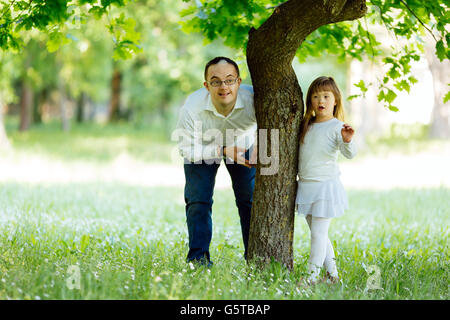 Down-Syndrom-Geschwister spielen im freien Stockfoto