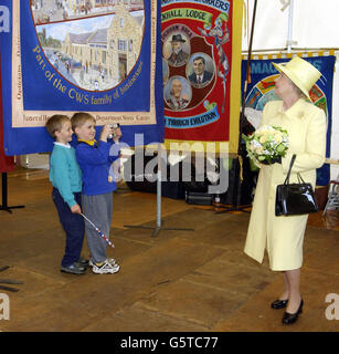 Die Königin Elizabeth II. Wird von zwei jungen Bewunderern gefilmt, während sie am zweiten Tag ihrer Golden Jubilee-Tournee durch Nordostengland in Easington, County Durham, Gewerkschaftsbanner ansieht. Easington Colliery, ist der Schauplatz einer der schlimmsten Bergbaukatastrophen in der britischen Geschichte. * die Königin wird drei Rettungskräfte aus der Tragödie von 1951 treffen. Stockfoto