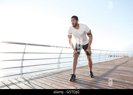 Fokussierter afroamerikanischer jungen Sportler ist bereit für den start am pier Stockfoto