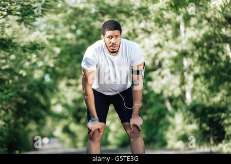 Müde schönen afrikanischen Sportler stehen und ruhen Sie sich nach Joggen im park Stockfoto