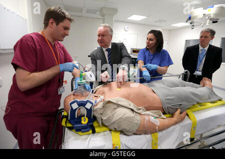 Gesundheitsminister Alex Neil mit Roboterpatient 'Stan', beobachtet von Registrar Dr. Stephen Hickey (ganz links) und Anästhesistin Dr. Donna Fraser (blaues Kleid) und Dr. Michael Moneypenny (ganz rechts) bei einem Besuch im Scottish Clinical Simulation Center im Forth Valley Royal Hospital. Stockfoto