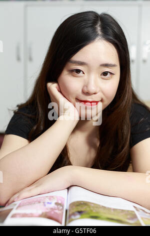 Ein Mode-asiatische Mädchen liest ein Buch Stockfoto