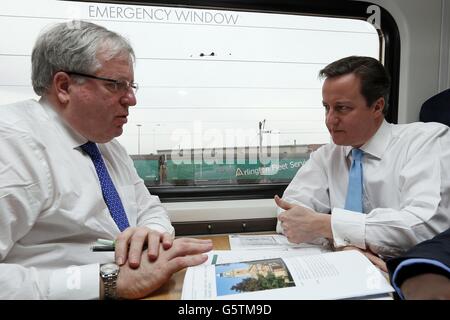 Premierminister David Cameron (rechts) und Verkehrsminister Patrick McLoughlin (links) reisen mit dem Zug zu einem regionalen Kabinettstreffen in Leeds. Stockfoto