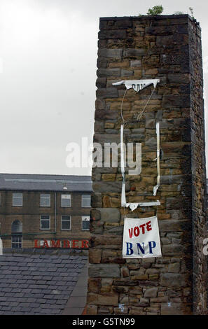 Ein Transparent, das hoch oben auf einem alten Mühlenkamin in der Nähe des Stadtzentrums von Burnley hängt, ermutigt die Wähler bei den Kommunalwahlen nächste Woche, für die britische Nationalpartei zu stimmen, die 13 Kandidaten in Bezirken um die Stadt aufstellen. Stockfoto