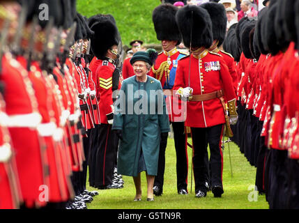 Die britische Königin Elizabeth II. Lächelt, als sie die Schotten-Wachen im Schloss Windsor mit dem Oberst des Regiments inspiziert, hat sie sowohl dem 1. Bataillon als auch der F-Kompanie, dem früheren 2. Bataillon, neue Farben verliehen. *... Die neuen Farben tragen die neuesten Kampfehren der Schotten-Garden und sind gestickt: Golf 1991. Stockfoto