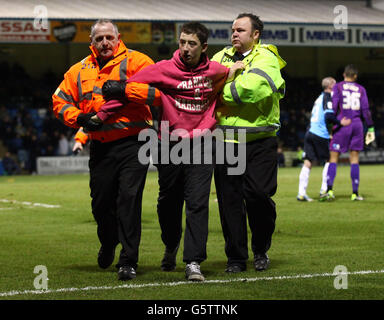 Ein junger Gillingham-Fan wird von Stewards angegriffen, nachdem er während des npower League Two-Spiels im MEMS Priestfield Stadium, Gillingham, auf Wycombe-Torwart Jordan Archer gesprungen ist. Stockfoto