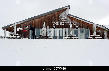 Im Café Boe Rigg in Charlton in der Nähe von Bellingham in Northumberland räumt ein Mann Schnee von den Pfaden, nachdem es über Nacht schweren Schnee gegeben hat, da Teile Großbritanniens heute auf eine Rückkehr von Schnee und Sturmwind vorbereitet sind, weniger als zwei Wochen nachdem die Schneestürme die Schulen gestört hatten, Flughäfen und Verkehrsnetze. Stockfoto