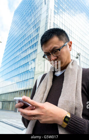 Paris, Frankreich, Chinese man using iPhone 6, Visiting New Modern Architecture Project, Neighborhood in Paris Rive Gauche, 'Tres Grande Bibliotheque', French National Library, (Credit Architect; Dominique Perrault) Smartphone Tourismus, Bibliothèque nationale de France Stockfoto