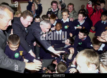 Taioseach Bertie Ahern greift zu Schülern, die in der Aufregung seines Wahlkampfbesuchs in der St. Patrick's National Boys Primary School in Galway zu Boden fielen, wo er bei einem Besuch mit der lokalen Fianna Fail Kandidatin Margaret Cox die Schulband spielen hörte. Stockfoto