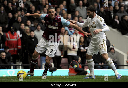 Andy Carroll von West Ham (links) hält Angel Rangel von Swansea City während des Spiels der Barclays Premier League im Upton Park, London, zurück. Stockfoto