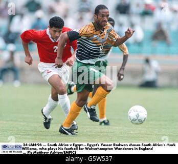 24-JAN-96. Südafrika – Ägypten. Yasser Radwan aus Ägypten jagt den Südafrikaner Mark Williams, der seinen Fußball für Wolverhampton Wanderers in England spielt Stockfoto