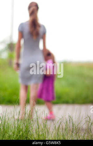 Silhouette von kleinen Mädchen, die im Besitz einer Hand der Mutter. Familienbeziehungen Konzept. Stockfoto