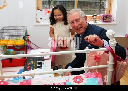 Prinz Charles spricht mit der sechsjährigen Kenadee in einer der Wohnungen, wo sie mit ihrer Mutter Angela Stephenson auf einer Tour durch Highbury Gardens in North London lebt, einer Wohnsiedlung, die mit Hilfe der Stiftung des Prinzen fertiggestellt wurde. Stockfoto