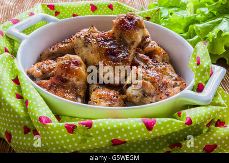 Gebratene Hähnchenflügel in weiße Auflaufform. Mit Sauce aus Senf, Honig und Sojasauce gekocht. Stockfoto