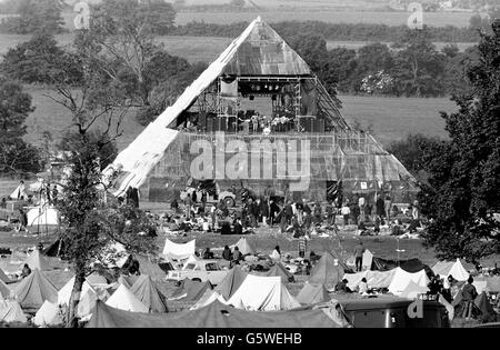 Eine Plastik-Pyramide schützt das Dais und wird von kleineren Zelten der Teilnehmer auf der würdigen Farm Pilton für das Glastonbury Festival umgeben. Stockfoto