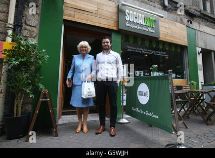 Die Herzogin von Cornwall, bekannt als Herzogin von Rothesay während in Schottland, mit Co-Gründer Josh Littlejohn, während eines Besuchs in sozialen Biss, eine Café in Edinburgh die feeds, trainiert und die Obdachlosen Gemeinschaft beschäftigt. Stockfoto