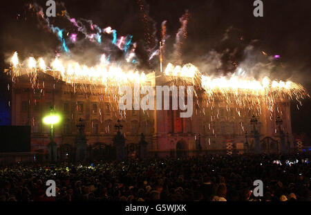 Feuerwerk brach über dem Buckingham Palace in London, nachdem die britische Königin Elizabeth II. Ein Leuchtfeuer entzündete, um an ihr goldenes Jubiläum zu erinnern. * früher hatten etwa 12,000 Leute die Party im Palast gesehen - das zweite Konzert, das in drei Tagen auf dem Gelände stattfinden wird - eine Menge schätzungsweise eine Million Leute versammelten sich draußen, um die Musik zu genießen. Am Dienstag wird sie zu einem Dankgottesdienst zu den St. Paul's reisen. Stockfoto