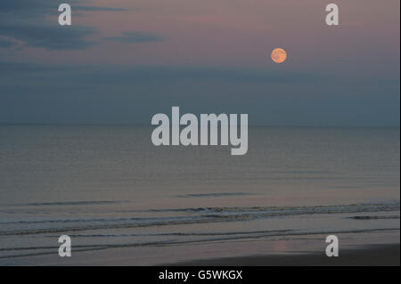 Die Erdbeere Mondaufgang über der Nordsee in der Nähe von Bridlington in East Yorkshire zur Sommersonnenwende Stockfoto