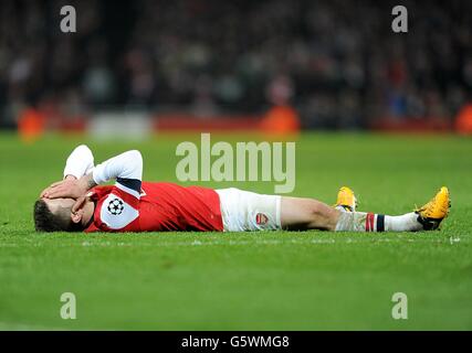 Fußball - UEFA Champions League - 16. Runde - Erstes Bein - Arsenal gegen Bayern München - Emirates Stadium. Jack Wilshere von Arsenal liegt auf dem Spielfeld niedergeschlagen Stockfoto