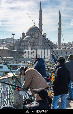 Fischer am Galata Brücke mit der Yeni oder neue Moschee von Eminönü im Hintergrund. Istanbul, Türkei. Stockfoto