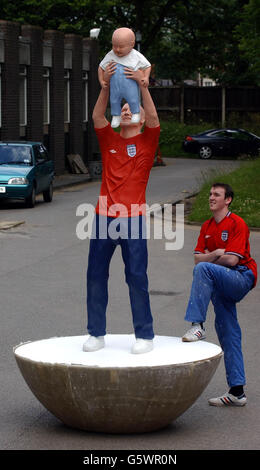 England Football Captain David Beckham wird als lebensgroßer Subbuteo-Spieler gezeigt, der seinen Sohn Brooklyn in dieser Skulptur hält, die der Student Mathew Chaloner, 22 (rechts), im Rahmen der Sunderland's 2002 Art, Design and Media Degree Show Exhibition in the City, enthüllt hat. *der leidenschaftliche Liverpool-Fan Matthew Chaloner hat seine Verborgenheit beiseite gelegt, das Fiberglas-Modell der Manchester United Nummer sieben in den letzten 17 Wochen zu gestalten. Stockfoto