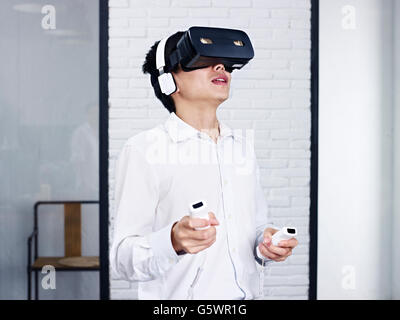 junge asiatische Mann Rollenspiel mit virtueller Realität (VR) Brille. Stockfoto