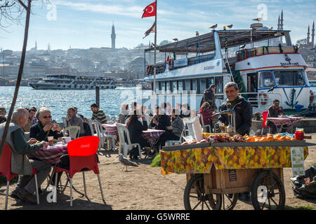 Cafés auf Karakoy Uferpromenade, Blick über das Goldene Horn auf die Yeni-Moschee auf Eminönü und die Skyline von Istanbul. Istanbul Stockfoto