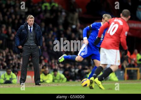 Everton-Manager David Moyes (links) sieht von der Touchline aus Sein Spieler Phil Neville (Mitte) übernimmt den Wayne von Manchester United Rooney (rechts) Stockfoto