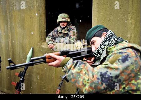 Schnee fällt auf die Salisbury Plain, wo Schauspieler mit Soldaten der britischen Armee die Rolle der afghanischen Streitkräfte spielen, um ihre Ausbildung zu realitätsnah zu machen, da eine mechanisierte Brigade ihre letzten Phasen der Ausbildung vor dem Einsatz abschließt, bevor sie auf eine Sommertour in der Operation Herrick 18 in die Provinz Helmand in Afghanistan aufbricht. Stockfoto